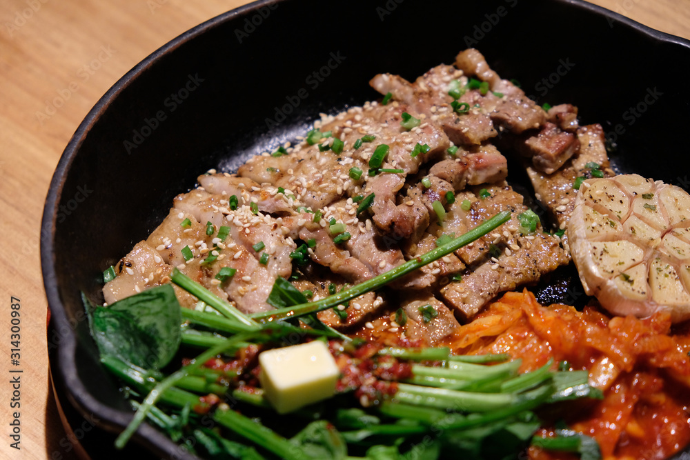 close up roast pork in black pan on wooden table. popular Korean cuisine close up roast pork in black pan on wooden table. popular Korean cuisine
