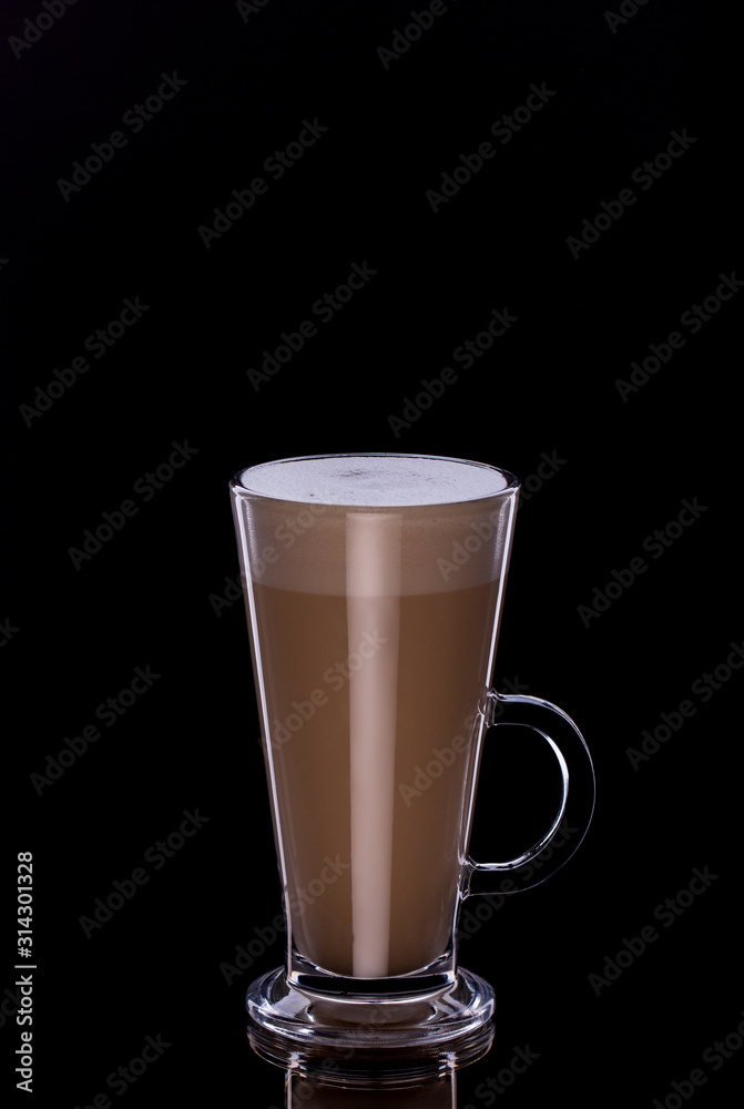Latte coffee in glass cup with foam on black background
