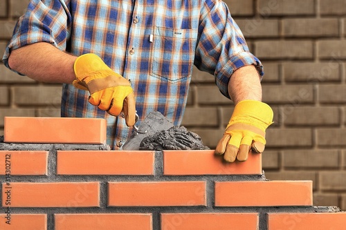 Bricklayer worker installing brick masonry