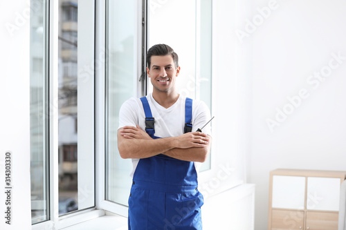 Billede på lærred Repairman with screwdriver near plastic window indoors