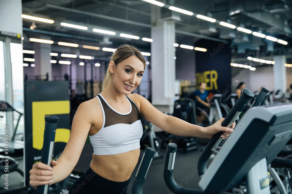 young beautiful girl doing exercises in the gym, jogging on the track indoors, fitness and crossfit young beautiful girl doing exercises in the gym, jogging on the track indoors, fitness and crossfit