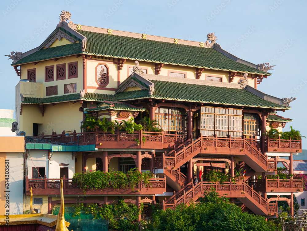 Phat Hoc Pagoda buddhist temple in Can Tho city centre, Mekong Delta region, Vietnam. Religious architecture, multi storey building front view, clear blue sky,