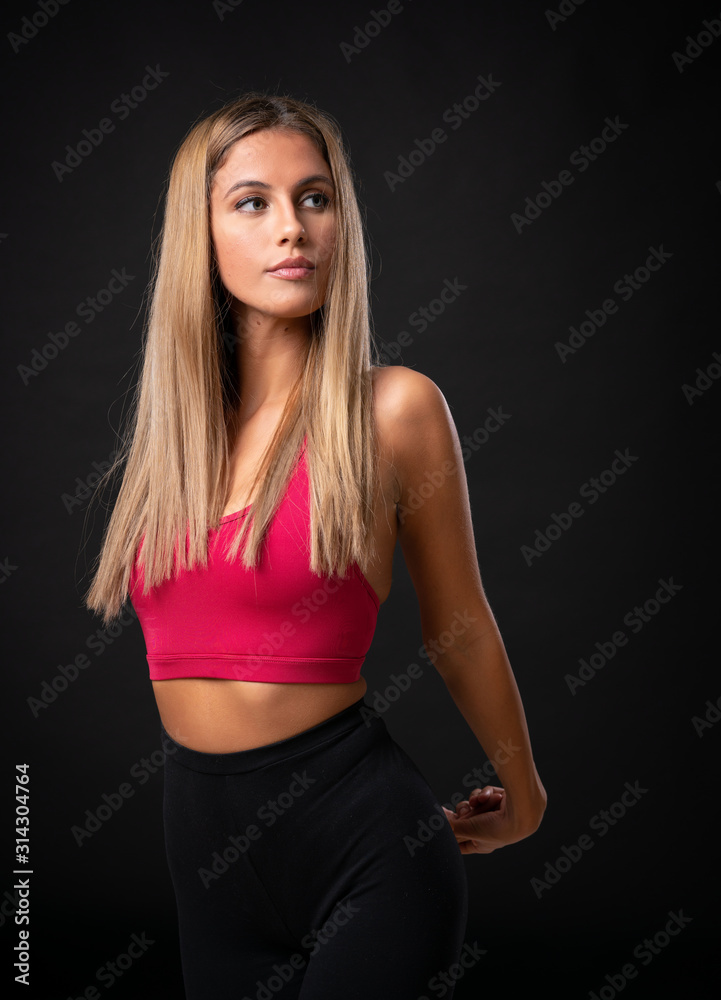 Young sport blonde woman over isolated black background Young sport blonde woman over isolated black background