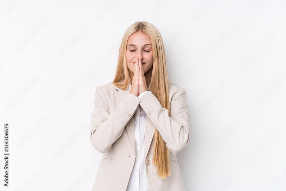 Young business blonde woman on white background holding hands in pray near mouth, feels confident. Young business blonde woman on white background holding hands in pray near mouth, feels confident.