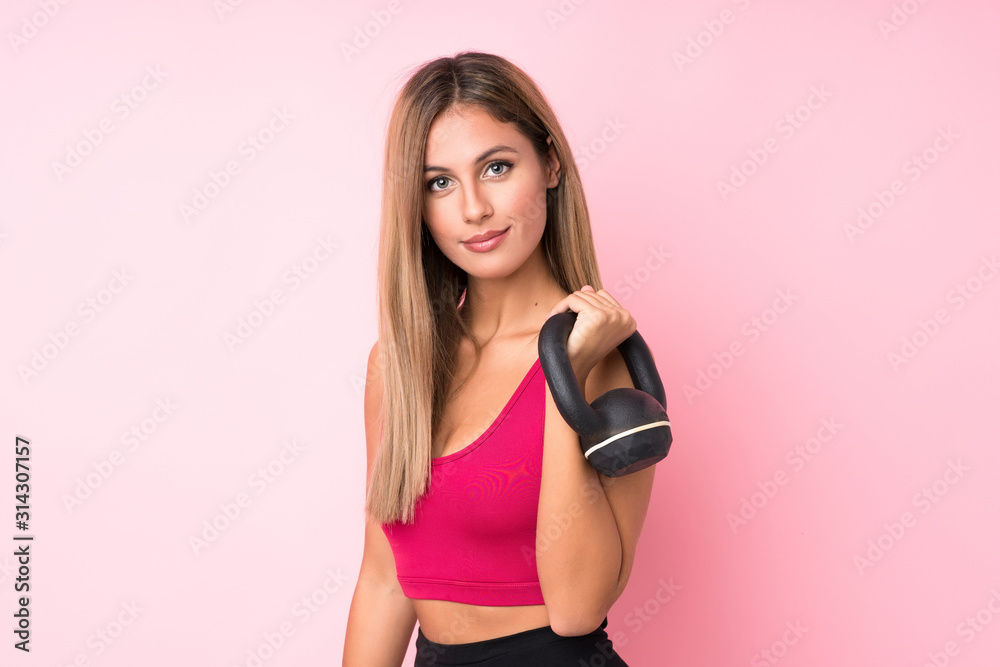 Young sport blonde woman over isolated pink background making weightlifting Young sport blonde woman over isolated pink background making weightlifting