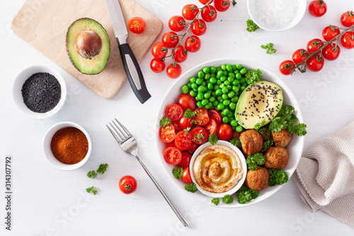 healthy vegan lunch bowl with falafel hummus tomato avocado peas