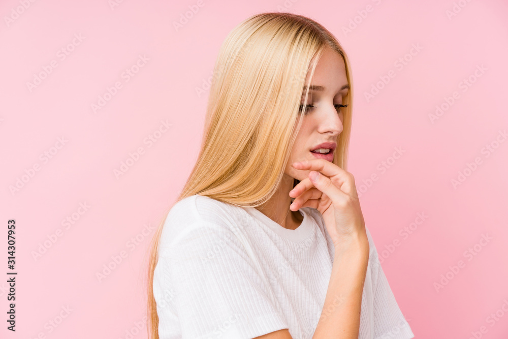 Young blonde woman face closeup isolated on a pink background Young blonde woman face closeup isolated on a pink background