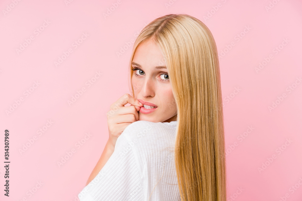 Young blonde woman face closeup isolated on a pink background Young blonde woman face closeup isolated on a pink background