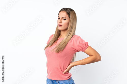 Young blonde woman over isolated white background suffering from backache for having made an effort © luismolinero