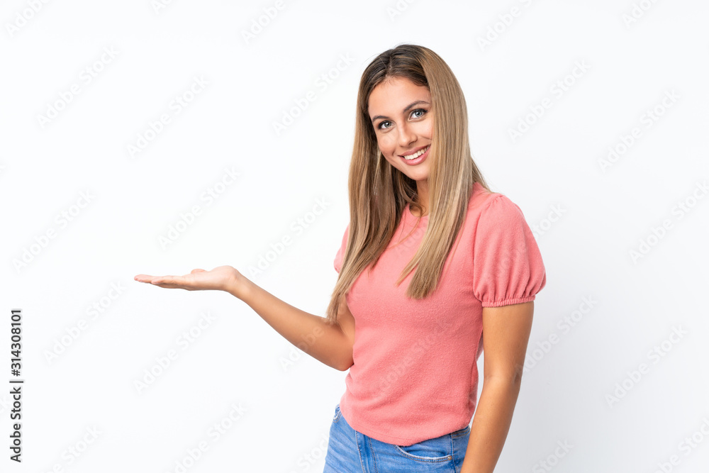 Young blonde woman over isolated white background presenting an idea while looking smiling towards Young blonde woman over isolated white background presenting an idea while looking smiling towards