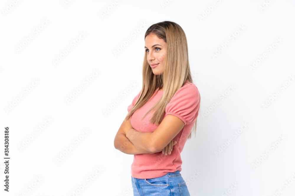 Young blonde woman over isolated white background in lateral position Young blonde woman over isolated white background in lateral position