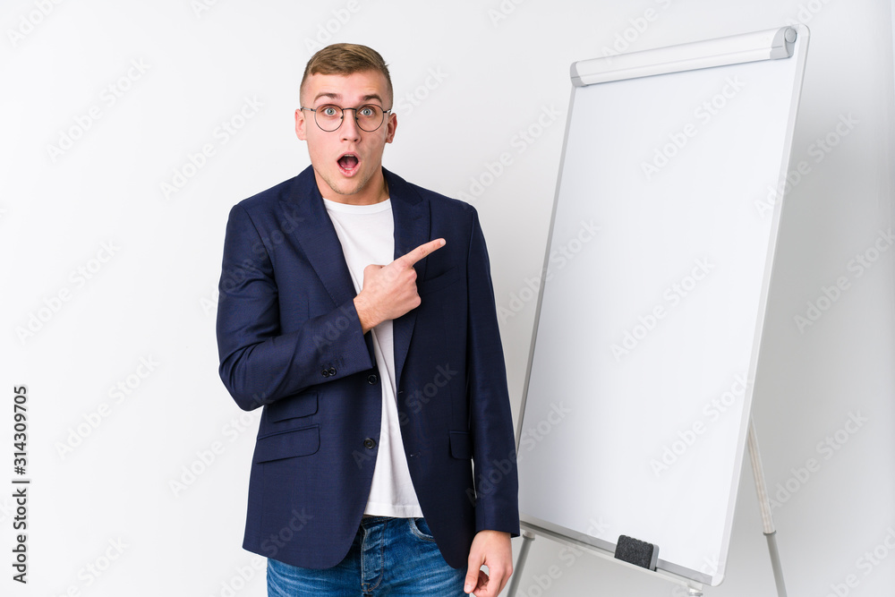 Young coaching man showing a white board pointing to the side Young coaching man showing a white board pointing to the side