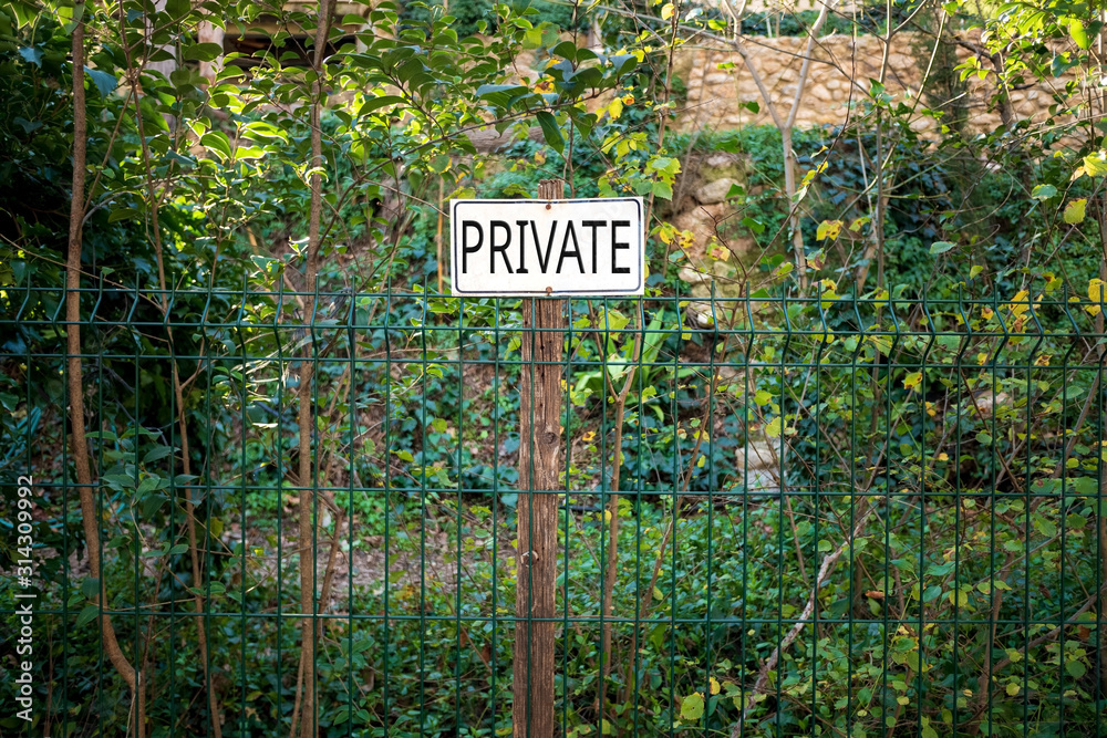 Poster on a fence in an orchard warning of private property.