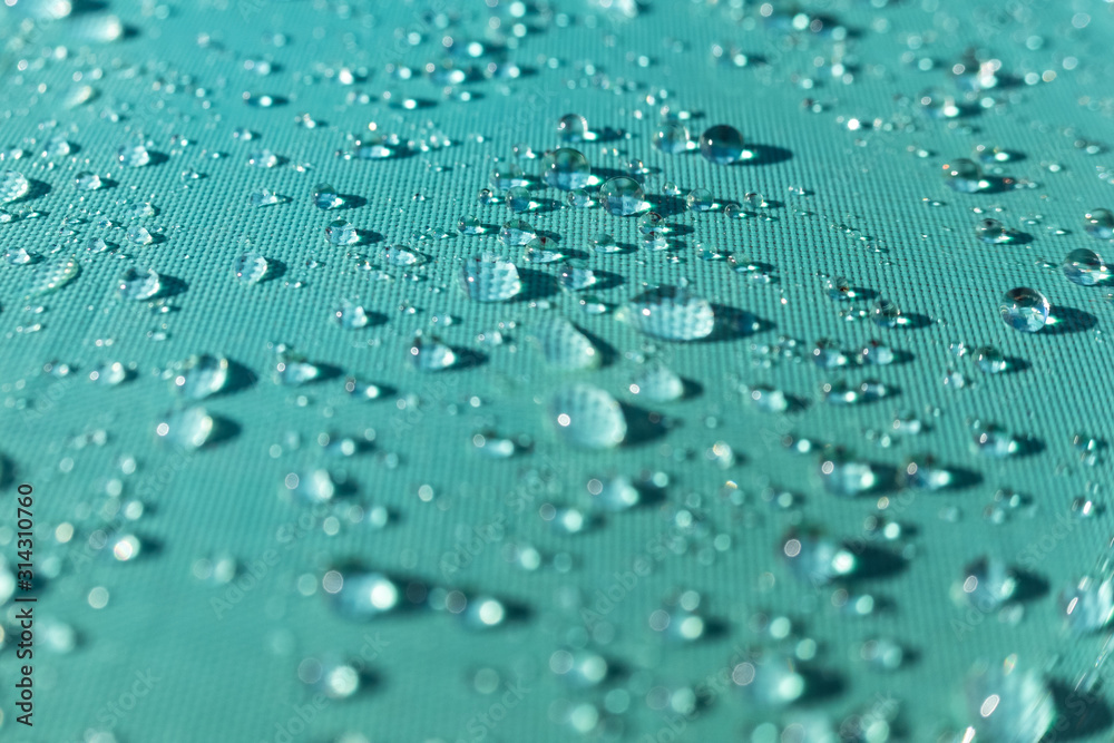 Close-up of natural and refreshing raindrops on the fabric of a colored umbrella.