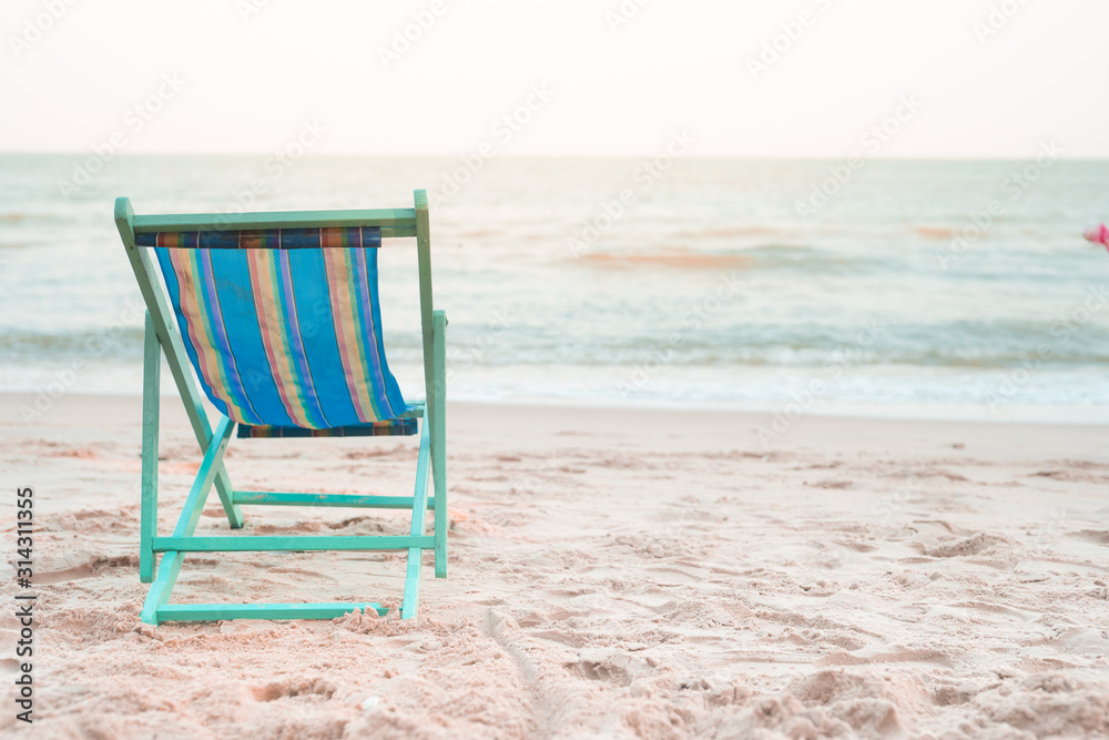 beach chair at side of beach with sunset background on autumn season beach chair at side of beach with sunset background on autumn season