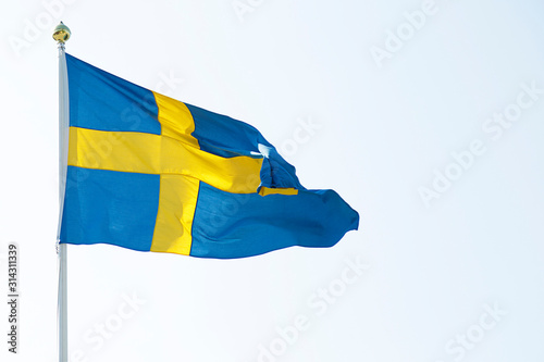 National flag of Sweden waving in the wind against the blue sky