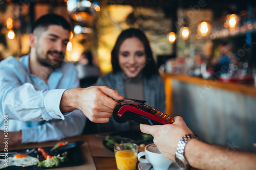 man paying with credit card in restaurant photo