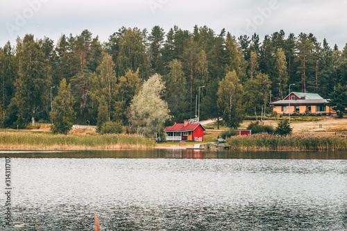 wooden building on the lake shore near autumn pine forrest