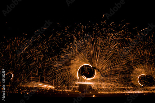 Fire dancing show in the night time, dark background 