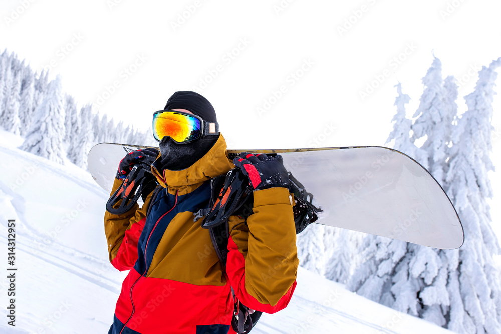 Active male snowboarder with beautiful winter landscape in the background
