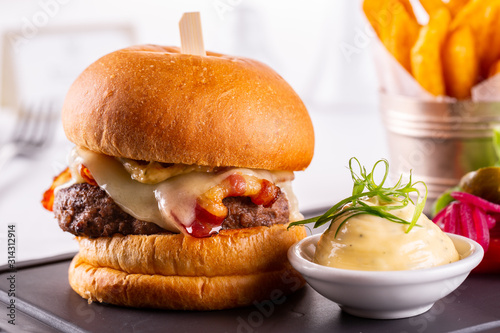Hamburger cheese with cutlet and ketchup  served with cheese sauce