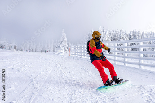 Snowboarder enjoys snowboard ride in mountain ski resort