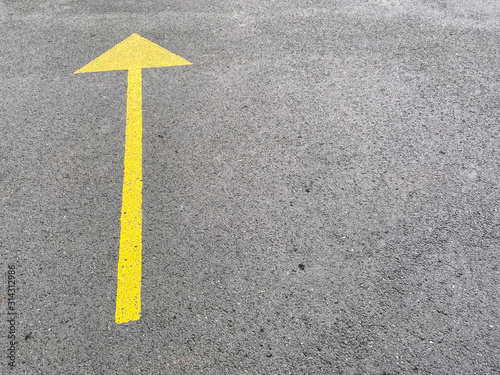 Image of yellow arrow on asphalt 