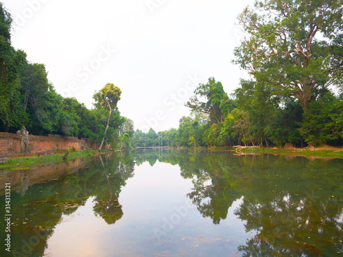 Landscape view of pond and tree reflection at Preah Khan temple Angkor Wat complex, Siem Reap Cambodia. A popular tourist attraction nestled among rainforest.