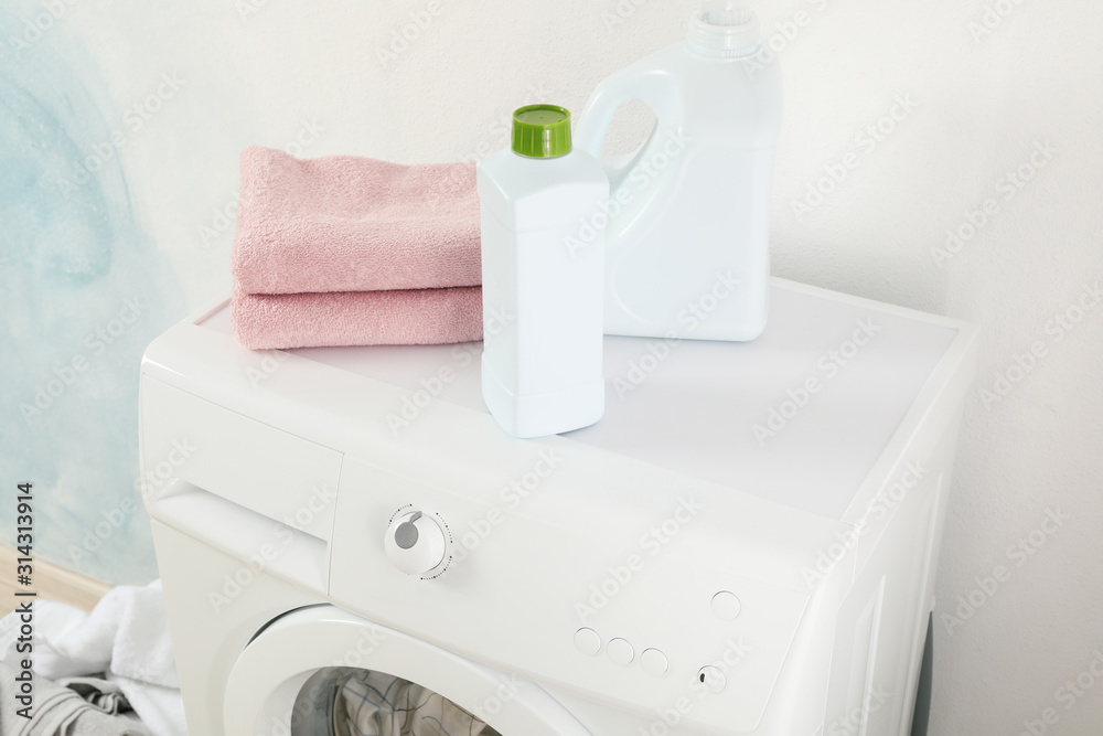 Detergents and towels on washing machine, close up Detergents and towels on washing machine, close up