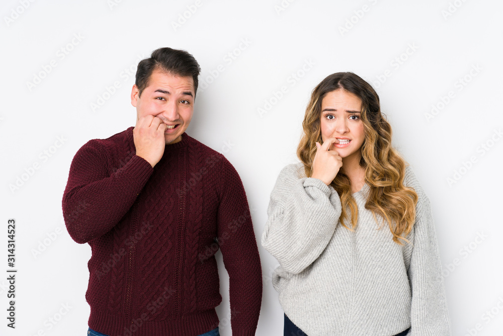 Young couple posing in a white background biting fingernails, nervous and very anxious. Young couple posing in a white background biting fingernails, nervous and very anxious.