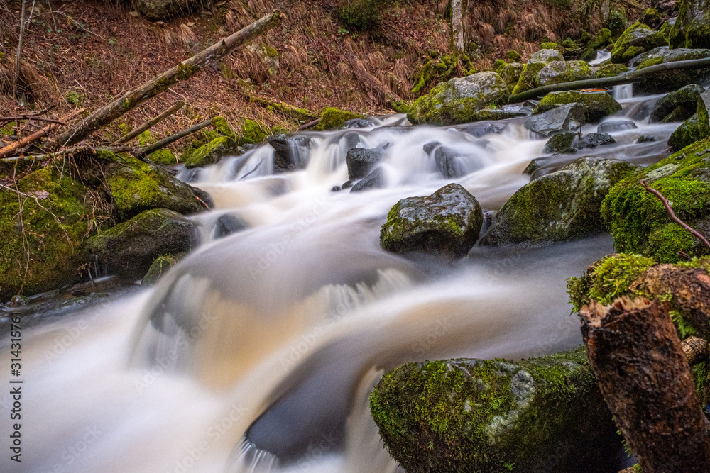 Langzeitbelichtung von einem Wildbach über Felsen Langzeitbelichtung von einem Wildbach über Felsen