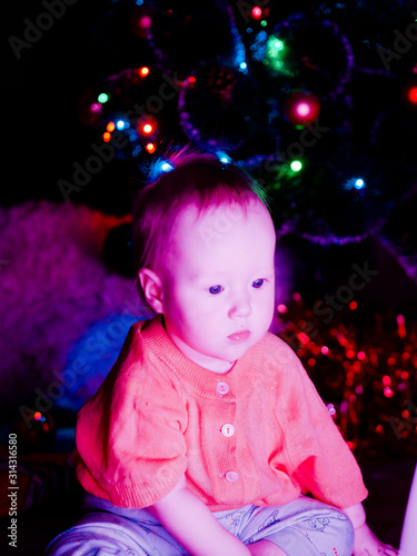 Baby with toys on the background of the Christmas tree
