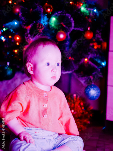 Baby with toys on the background of the Christmas tree