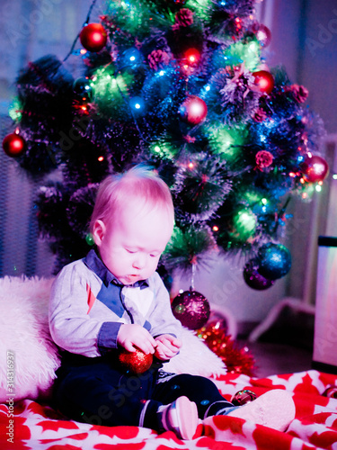 Baby with toys on the background of the Christmas tree