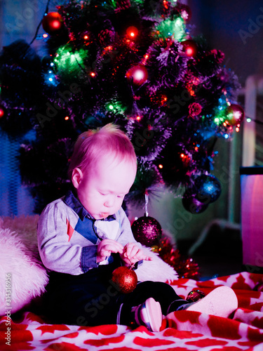 Baby with toys on the background of the Christmas tree