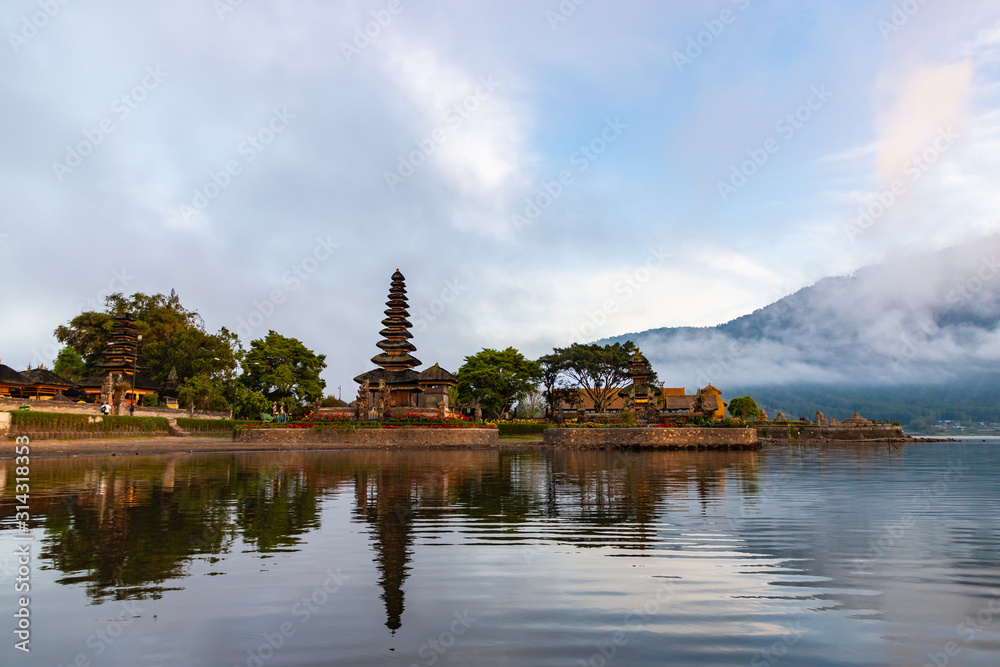 Morning at Pura Ulun Danu Bratan, Hindu temple on Bratan lake. Photo from boat, one of famous tourist attraction in Bali, Indonesia Morning at Pura Ulun Danu Bratan, Hindu temple on Bratan lake. Photo from boat, one of famous tourist attraction in Bali, Indonesia