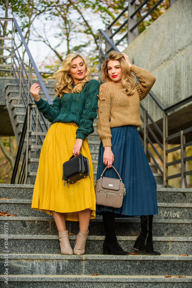 Sweater skirt trend. Completing each other. Vogue concept. Girls blonde  wear matching clothes. Matching outfits. Women sisters outdoors stairs  background. Matching colors. Personal stylist service Stock-Foto | Adobe  Stock