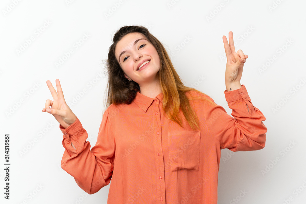 Young brunette girl over isolated white background showing victory sign with both hands Young brunette girl over isolated white background showing victory sign with both hands