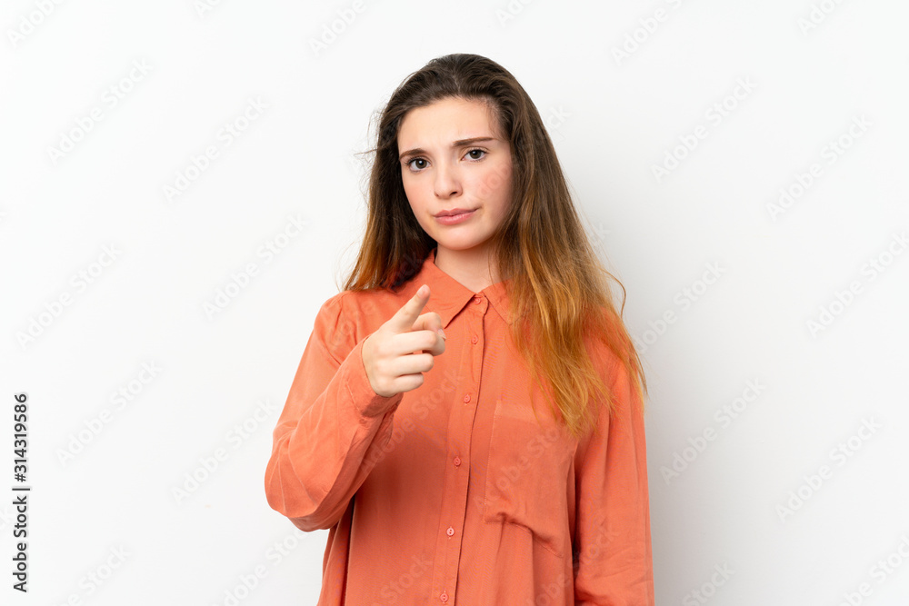 Young brunette girl over isolated white background frustrated and pointing to the front Young brunette girl over isolated white background frustrated and pointing to the front