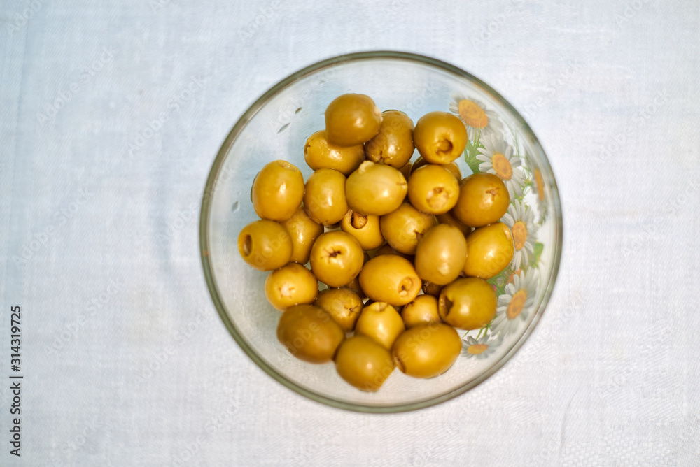 Stuffed olives in a cup on a light background Stuffed olives in a cup on a light background