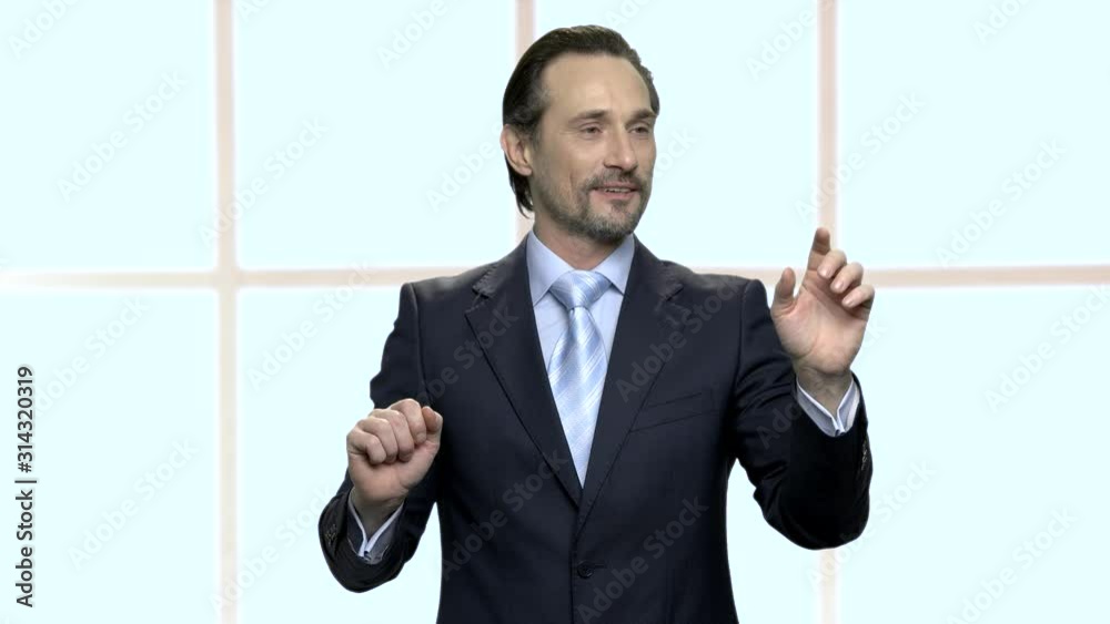 Confident mature businessman working with virtual screen. Handsome project manager touching an invisible interface at office. People, business, modern technology concept. Confident mature businessman working with virtual screen. Handsome project manager touching an invisible interface at office. People, business, modern technology concept.
