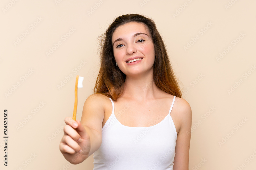 Young brunette girl brushing her teeth.over isolated background Young brunette girl brushing her teeth.over isolated background