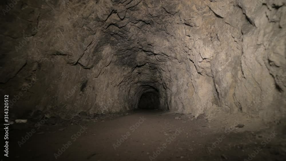Speleology artificial cave dark tunnel excavation underground. Old adit for the extraction of metal and rocks
