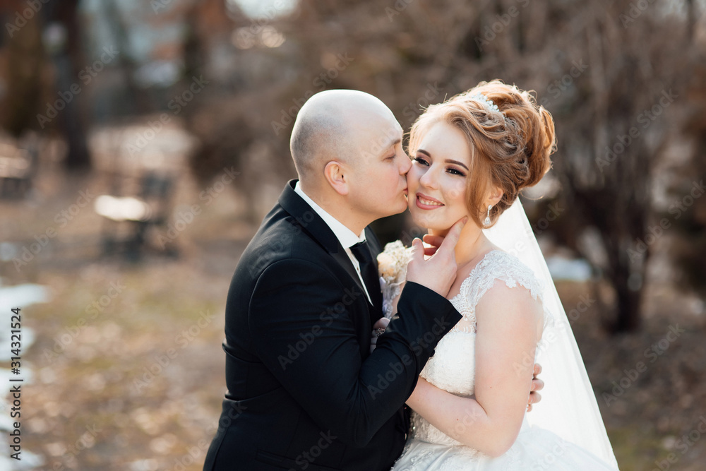 Beautiful couple in love newlyweds. Bride and groom at wedding day walking outdoors. Stylish and beautiful. Bridal couple, newlywed woman and man embracing with love. Wedding day. Beautiful couple in love newlyweds. Bride and groom at wedding day walking outdoors. Stylish and beautiful. Bridal couple, newlywed woman and man embracing with love. Wedding day.