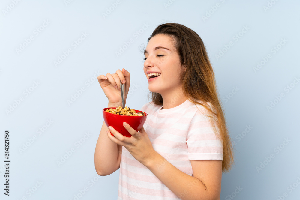 Young brunette girl holding a bowl of cereals over isolated background Young brunette girl holding a bowl of cereals over isolated background