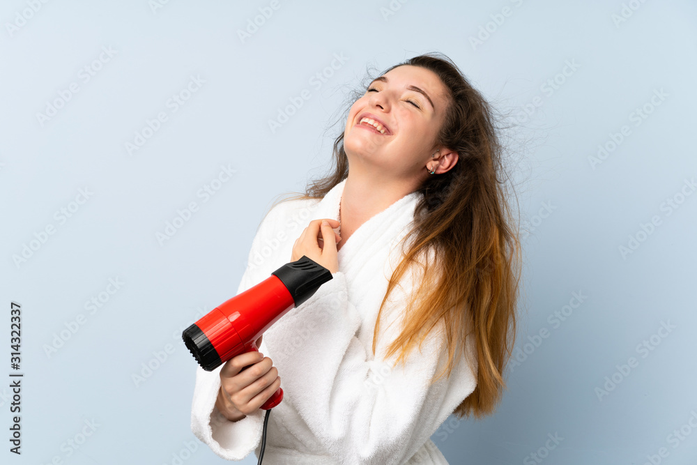 Young woman in a bathrobe with hair hairdryer Young woman in a bathrobe with hair hairdryer