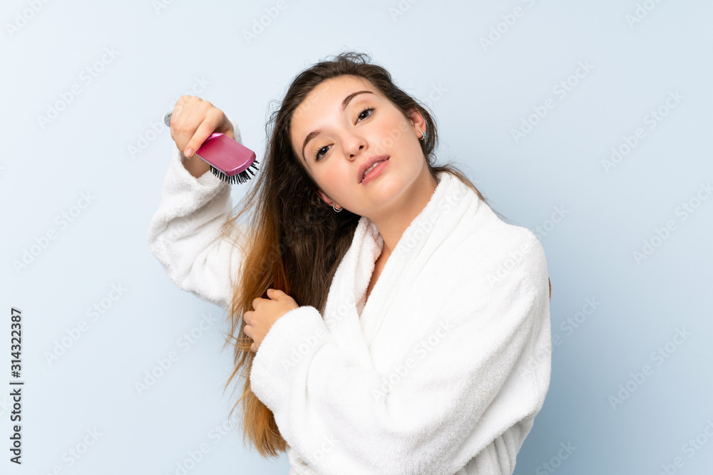 Young woman in a bathrobe with with hair comb. Young woman in a bathrobe with with hair comb.
