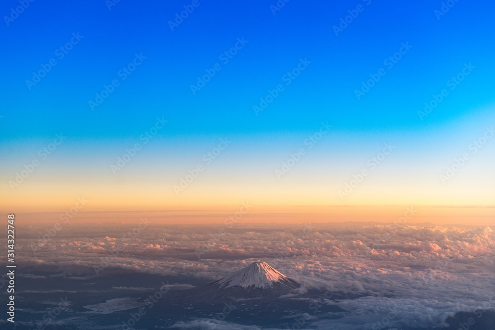 雲海の夕焼けに染まる雪の富士山