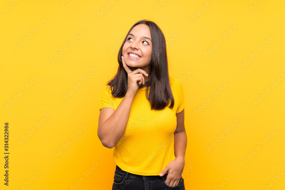 Young brunette girl over isolated background thinking an idea while looking up Young brunette girl over isolated background thinking an idea while looking up