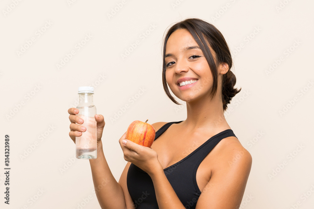 Young brunette girl with an apple and with a bottle of water over isolated background Young brunette girl with an apple and with a bottle of water over isolated background